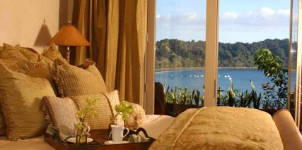 Bed with tray looking at the ocean from Marbella Condominium